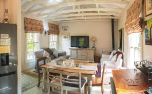 a living room with a table and a tv at The French Cottage in Clarens