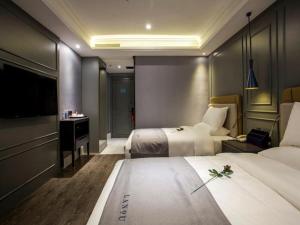 Habitación de hotel con 2 camas y TV de pantalla plana. en LanOu Hotel Ningyang Qixian Road Yizhong, en Ningyang