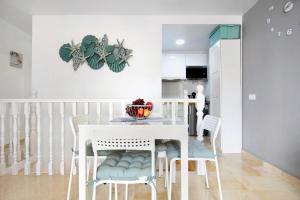 eine Küche und ein Esszimmer mit einem weißen Tisch und Stühlen in der Unterkunft Sol y Mar Caleta de Fuste in Caleta de Fuste