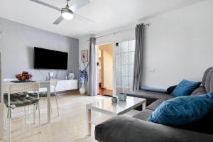 ein Wohnzimmer mit einem Sofa und einem Tisch in der Unterkunft Sol y Mar Caleta de Fuste in Caleta de Fuste