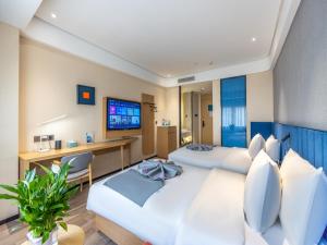 a hotel room with two beds and a television at LanOu Hotel Lanzhou Zhengning Road Night Market in Lanzhou