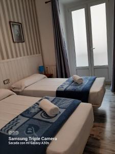 pokój hotelowy z 3 łóżkami i ręcznikami w obiekcie Pensión San Isidro w Madrycie