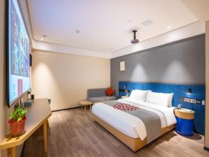 Habitación de hotel con cama grande y TV de pantalla plana. en LanOu Hotel Lanzhou Zhengning Road Night Market en Lanzhou
