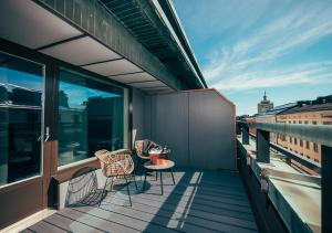 - un balcon avec deux chaises et une table dans un bâtiment dans l'établissement Hotel Mestari, à Helsinki