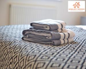 a stack of towels sitting on top of a bed at Flawless - City Centre - Free Parking - HPC - 5 - By Hinkley Homes Short Lets & Serviced Accommodation in Bridgwater +59 photos