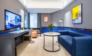 a living room with a blue couch and a table at LanOu Hotel Jingzhou East Gate of Ancient City Wanda Plaza in Jingzhou