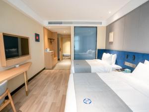 a hotel room with two beds and a flat screen tv at LanOu Hotel Xiaonan District Wanda Plaza in Xiaogan
