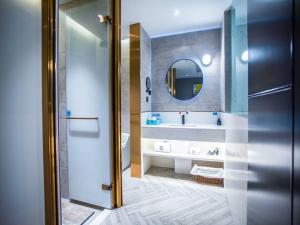a bathroom with a sink and a mirror at LanOu Hotel Jingzhou East Gate of Ancient City Wanda Plaza in Jingzhou