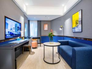a living room with a blue couch and a table at LanOu Hotel Jingzhou East Gate of Ancient City Wanda Plaza in Jingzhou