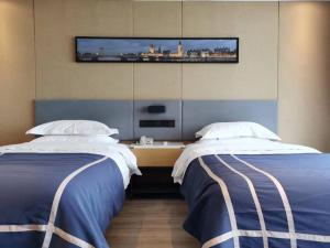 Habitación de hotel con 2 camas y TV en la pared en LanOu Hotel Lianyungang Donghai Anfeng Town, en Donghai