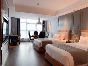 Habitación de hotel con 2 camas y escritorio en LanOu Hotel Shaoyang Shangbang Jiayuan, en Shaoyang County