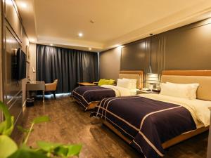 a hotel room with two beds and a desk at LanOu Hotel Suzhou Yongqiao Yingbin Avenue in Suzhou