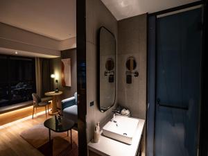 La salle de bains est pourvue d'un lavabo et d'un miroir. dans l'établissement LanOu Hotel Longkou Boshang Shopping Plaza, à Longkou