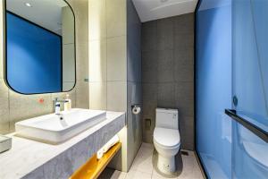 a bathroom with a sink and a toilet and a mirror at LanOu Hotel Zigong Yantan Longhu Food Plaza in Zigong