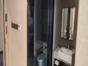 a bathroom with a sink and a mirror and a toilet at LanOu Hotel Lianyungang Donghai Anfeng Town in Donghai