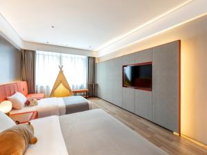 a hotel room with two beds and a flat screen tv at LanOu Hotel Shanghai Sheshan National Forest Park Happy Valley in Songjiang