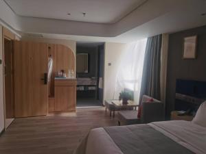 a hotel room with a bed and a living room at LanOu Hotel Tianshui Bus Terminal Station in Tianshui