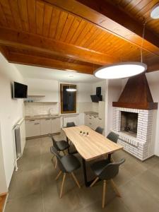 une salle à manger avec une table, des chaises et une cheminée dans l'établissement Apartment Nona Polda, à Kobarid