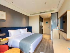 duże białe łóżko w pokoju hotelowym w obiekcie LanOu Hotel Shanghai Sheshan National Forest Park Happy Valley w mieście Songjiang