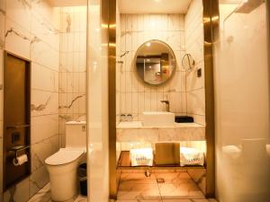 uma casa de banho com um WC, um lavatório e um espelho. em LanOu Hotel Suzhou Yongqiao Yingbin Avenue em Suzhou