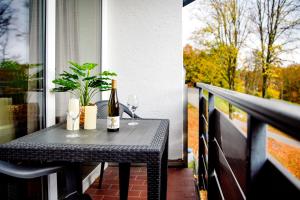 a table with a bottle of wine on a balcony at Smart Resorts Haus Saphir Ferienwohnung 508 in Winterberg