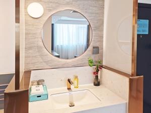 a bathroom with a sink and a mirror at LanOu Hotel Taocheng Hengshui Middle School in Hengshui