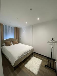 ノヴィ・パザルにあるGlass Apartmaniのベッドルーム1室(白いベッド1台、白いラグ付)