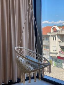 einen Korb, der von einem Fenster mit Aussicht hängt in der Unterkunft Glass Apartmani in Novi Pazar