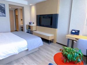 ein Hotelzimmer mit einem Bett und einem TV in der Unterkunft LanOu Hotel Golmud Middle Bayi Road in Golmud