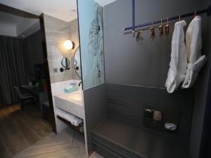 ein Badezimmer mit einem weißen Waschbecken und einem Spiegel in der Unterkunft LanOu Hotel Heze Mudan District University Town in Heze