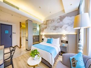 a hotel room with a large bed and a couch at LanOu Hotel Guilin Wanfu Plaza in Guilin