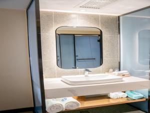 a bathroom with a sink and a mirror at LanOu Hotel Xiaonan District Wanda Plaza in Xiaogan