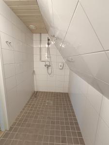 a bathroom with a shower and a tile floor at Joensuun Tilan Päärakennus in Söderkulla