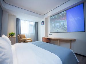 a hotel room with a bed and a flat screen tv at LanOu Hotel Tongren Wanshan Jinlin Avenue in Tongren