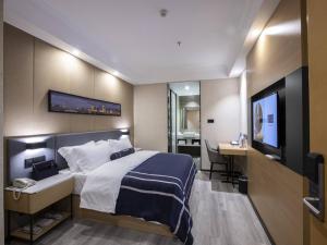 een slaapkamer met een bed en een flatscreen-tv bij LanOu Hotel Yucheng Yingbin Avenue in Yuncheng