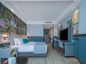 een hotelkamer met een groot bed en een televisie bij LanOu Hotel Tai'an Taishan Railway Station in Tai'an