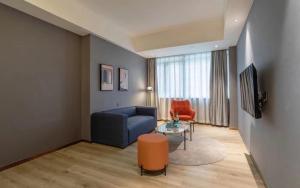 a living room with a blue couch and a table at LanOu Hotel Qingcheng Municipal Government Shunying Plaza in Qingyuan