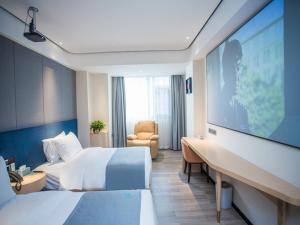 a hotel room with a large tv and a bed at LanOu Hotel Tongren Wanshan Jinlin Avenue in Tongren