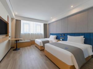 Habitación de hotel con 2 camas y TV de pantalla plana. en LanOu Hotel Linyi Railway Station National Fitness Center, en Linyi