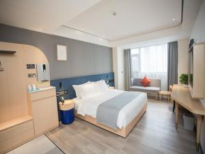 Pokój hotelowy z dużym łóżkiem i biurkiem w obiekcie LanOu Hotel Tongren Wanshan Jinlin Avenue w Tongren