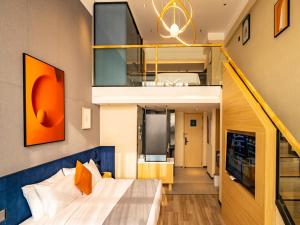 1 dormitorio con 1 cama grande y una escalera en LanOu Hotel Longkou Boshang Shopping Plaza, en Longkou