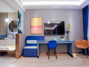 Habitación con escritorio azul y 2 sillas. en LanOu Hotel Taixing Wanda Plaza, en Taixing