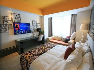 a bedroom with a large bed and a tv at LanOu Hotel Lianyungang Donghai Crystal City in Donghai