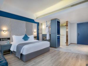 una grande camera da letto con un grande letto e un bagno di LanOu Hotel Shaoguan University a Shaoguan