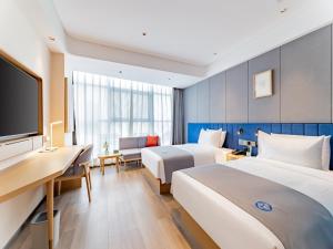 um quarto de hotel com duas camas e uma televisão de ecrã plano em LanOu Hotel Hohhot New Town Moore City em Hohhot