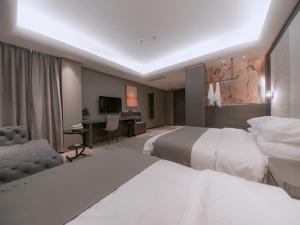 a hotel room with two beds and a desk at LanOu Hotel Chaozhou Xiangqiao District Plaza in Chaozhou