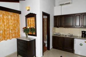 a kitchen with brown cabinets and a sink and a toilet at Afrodite Hotel Apartments in Myrina