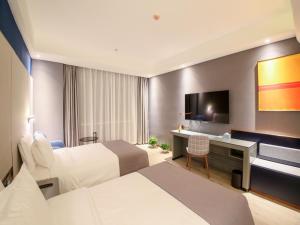 a hotel room with two beds and a desk and a television at LanOu Hotel Zhangye Hexi College Ganquan Park in Zhangye +30 photos
