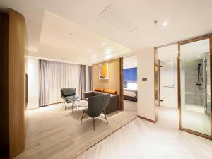 a room with two chairs and a couch and a table at LanOu Hotel Zhangye Hexi College Ganquan Park in Zhangye