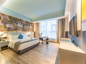 - une chambre avec un lit et un bureau dans l'établissement LanOu Hotel Qingdao Laixi Development Zone Beijing Road, à Laixi